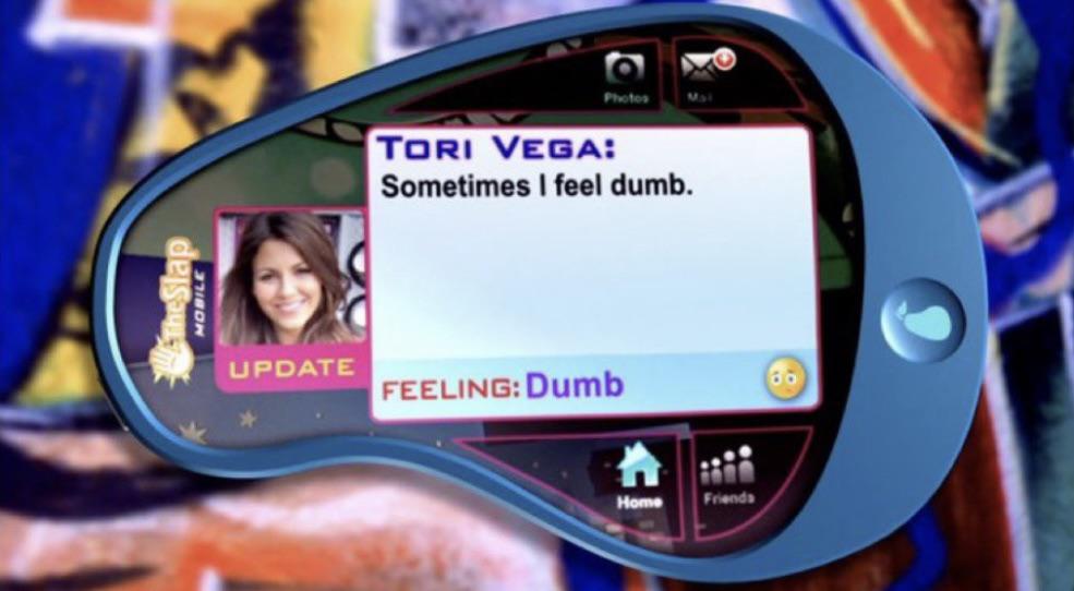 Cena da segunda temporada da série Brilhante Vitória, mostrando a atualização de status recorrente que os personagens fazem na rede social fictícia TheSlap.com. Na imagem, Tori Vega (a personagem de Victoria Justice) escreve no seu PeraPhone 'Sometimes i feel dumb' colocando no campo de reação de como está se sentindo como 'feeling:dumb' seguido de um emoji com cara de coitado